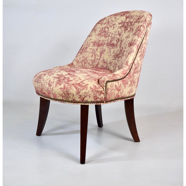 A pair of French style slipper chairs in Country French Toile upholstery with brass tack detailing and attractive splay...