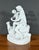 Antique porcelain sculpture depicting nude Venus seated on a rock with a putti with outstretched wings at her side. These...