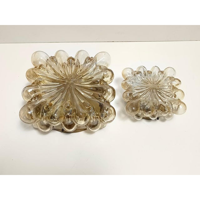 Finland, circa 1970. This is a postmodern ceiling light in varnished metal and yellow / amber glass by Helena Tynell. It...