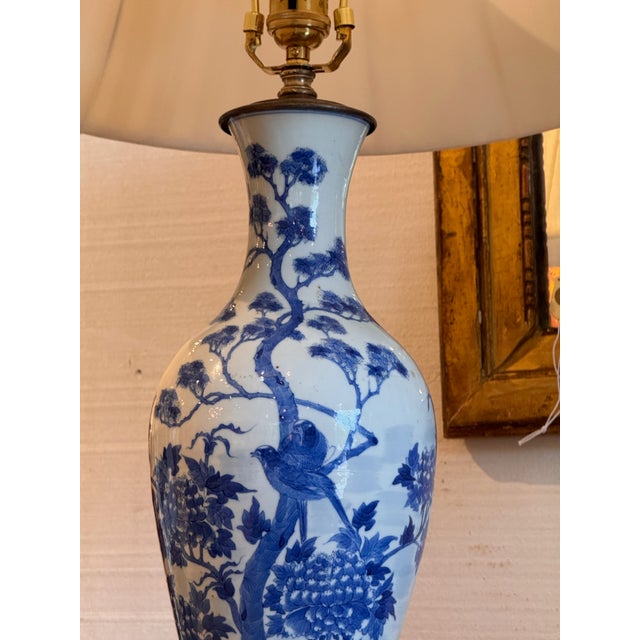 Pair of blue and white porcelain baluster vases mounted as table lamps, painted with flowering branches, peonies, and...