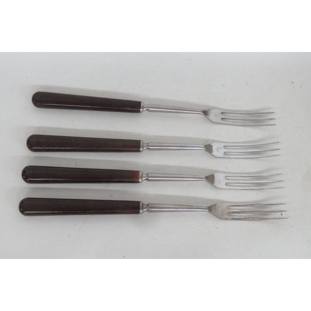 This lovely Set of 4 Forks is made out of stainless steel and wood. It features a lovely dark grain to the wood and long,...