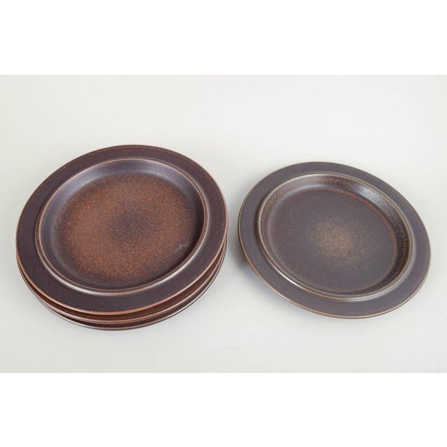 Arabia Finland Plates “Ruska”, 1960/70s. Four dinner plates in dark brown stoneware from Arabia’s iconic “Ruska” series,...