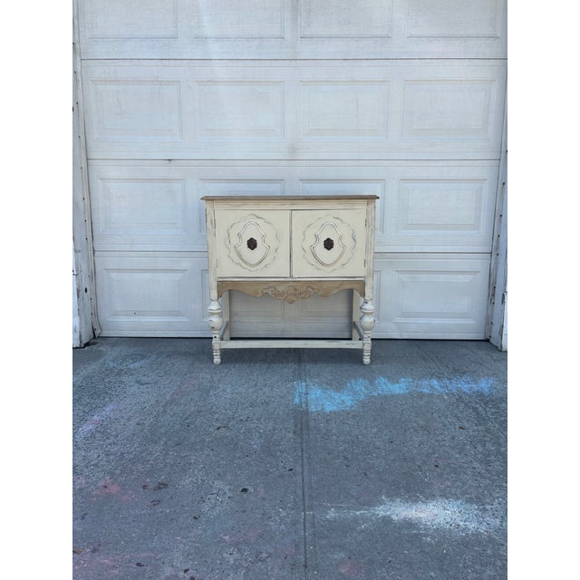 We have a beautiful distressed neutral cabinet featuring a warm wood top and a softly aged painted finish for sale. This...