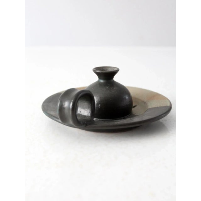 This is a vintage Beaver Creek studio pottery candlestick holder. The handmade chamberstick has a black, taupe, and tan...