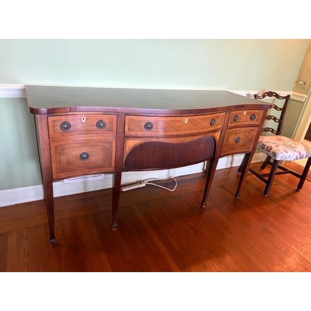 The Charak Mahogany Federal Serpentine Front Server is a vintage sideboard made of mahogany with a brass handle finish....