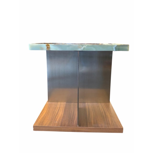 Elegant end table featuring a richly veined green onyx top paired with a warm wood base, creating a striking contrast...