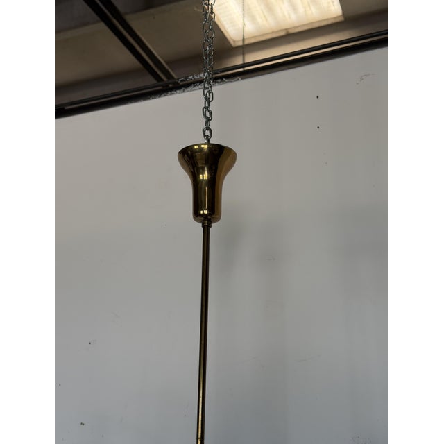 Elegant chandelier in polished brass and black, with white opal glass diffusers, designed by Bruno Gatta and produced by...