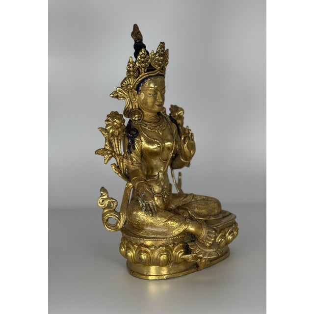 An exceptional antique Tibetan gilt bronze figure depicting Green Tara (Syamatara), the beloved female Bodhisattva of...