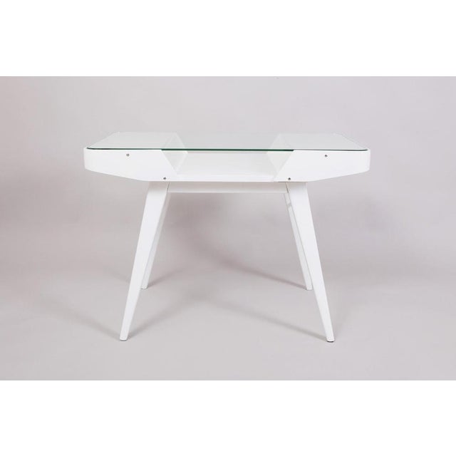 White mid century table made in the 1950s in Czechia. Designed by František Jirák and made by Tatra Nábytok. The table is...