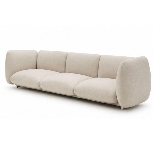 This Paola Lenti outdoor sofa offers both comfort and style with its soft cream fabric and unique rounded armrests....