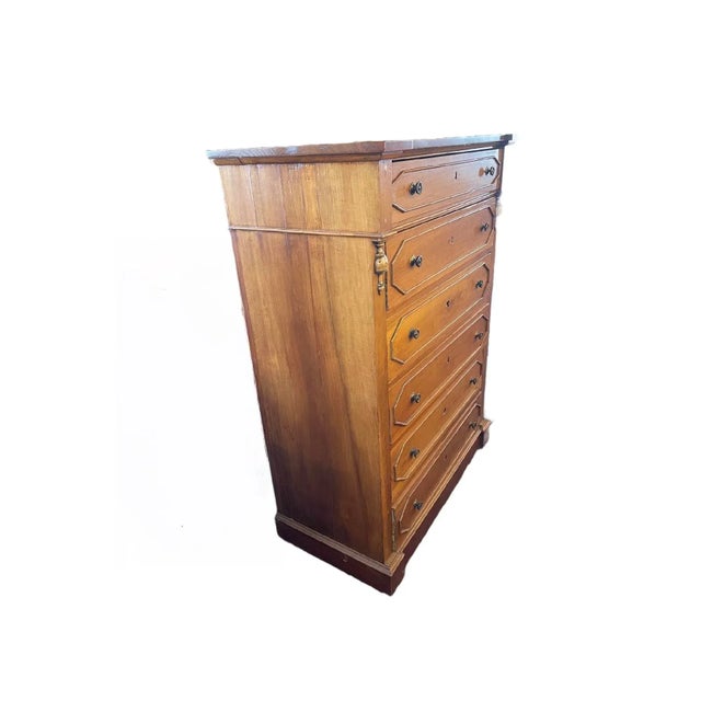 Tall walnut dresser that has 6 drawers. A transitional wooden piece made between the years of 1900-1909.