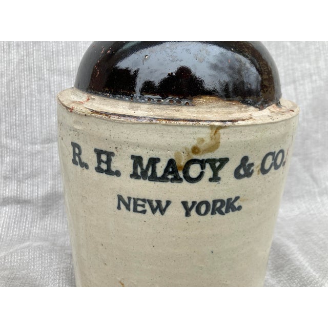 Antique glazed R. H. Macy & Co. New York salt glazed stoneware whiskey jug with handle. Remnants of the cork still in the...