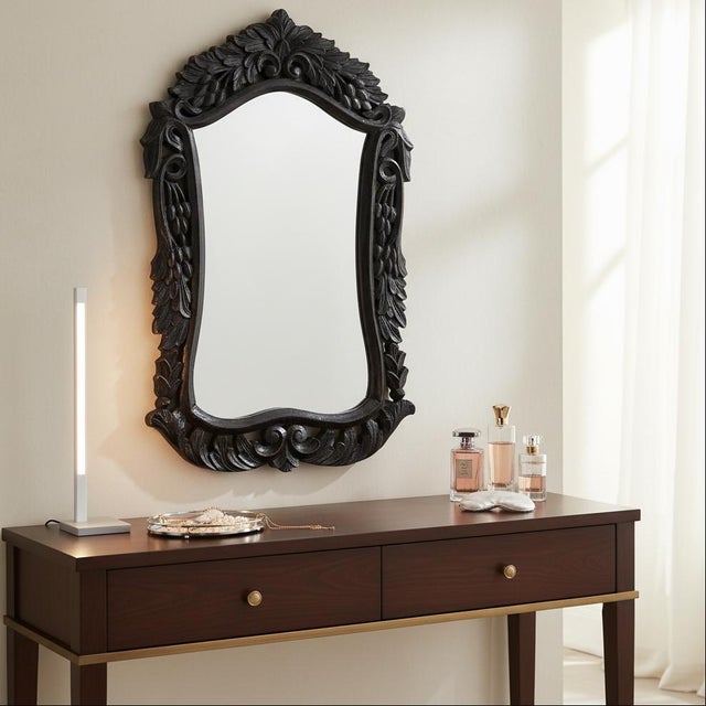 Dimensions: 16" W x 2" D x 25" H This mirror adorns hand carved scroll work and acanthus leaves on richly finished wood....