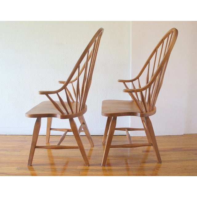 This is a pair of mid century modern style solid oak Windsor chairs that have arched fan backs with beautiful tapered...