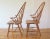 This is a pair of mid century modern style solid oak Windsor chairs that have arched fan backs with beautiful tapered...