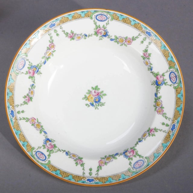 A set of 11 English Mintons Fine China wide rim bowls feature rim with floral swag and stylized foliate border, central...