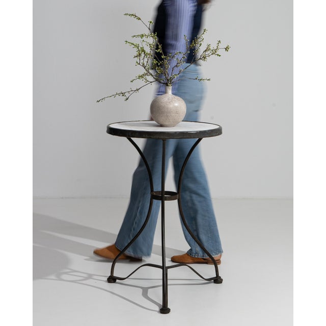 A classic French bistro table featuring a marble top and metal base, evoking Parisian café culture. The compact design and...