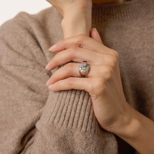 A striking symbol of unity and strength, this Mid Century buckle ring from the 1960s showcases eight shimmering old...