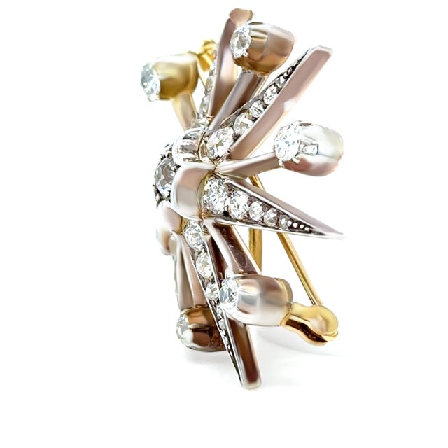 A stunning Victorian-era diamond starburst pendant/brooch crafted in 15ct yellow gold with a silver-topped setting,...
