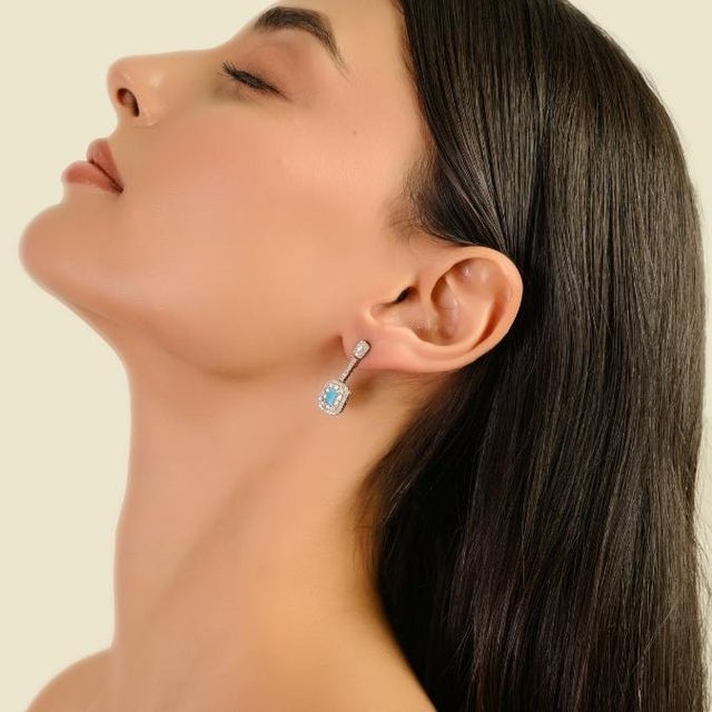 These convertible earrings in 14K white gold feature a baguette-cut natural turquoise measuring approximately 5 x 3 mm...