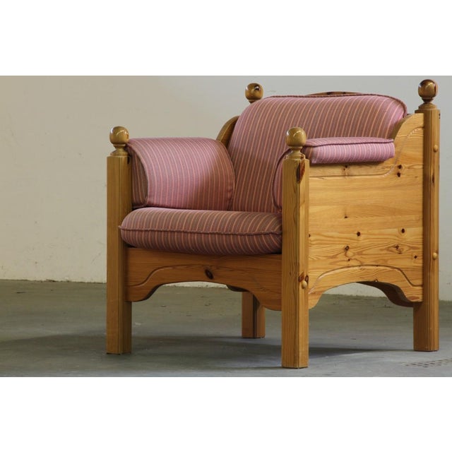 Crafted in Danish pine in the 1970s, this lounge chair stands as a quietly light hearted yet imposing piece, its patina...