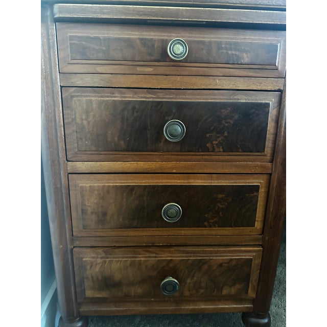 Large double pedestal executive desk in burl walnut veneer with antique brass reeded knobs and turned baluster legs. Eight...