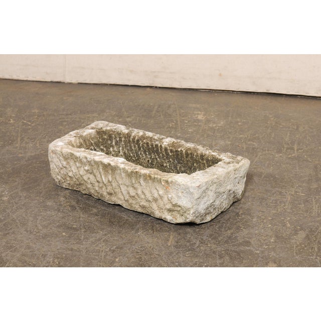 A Spanish carved stone basin or planter from the 19th century. This antique trough from Spain, has a rectangular shape...