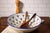 The Intreccio Large Serving Bowl brings centuries of Italian ceramic artistry to your table. Hand-painted by master...