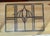 This vintage leaded glass window panel features a geometric design with a central stylized floral motif.The piece is...