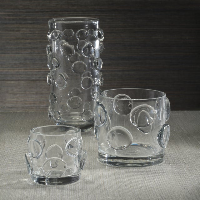 A striking fusion of texture and elegance, the Celeste Glass Candle Holder makes a captivating statement in any setting....