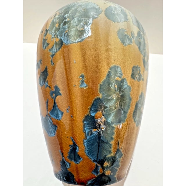 Signed studio pottery vase by Phil Morgan featuring a crystalline glaze in layered tones of amber, blue, and celadon. The...