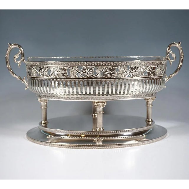 Representative elegant silver jardinière on oval, fluted stepped base, bordered by palmette bands, on top arranged in a...