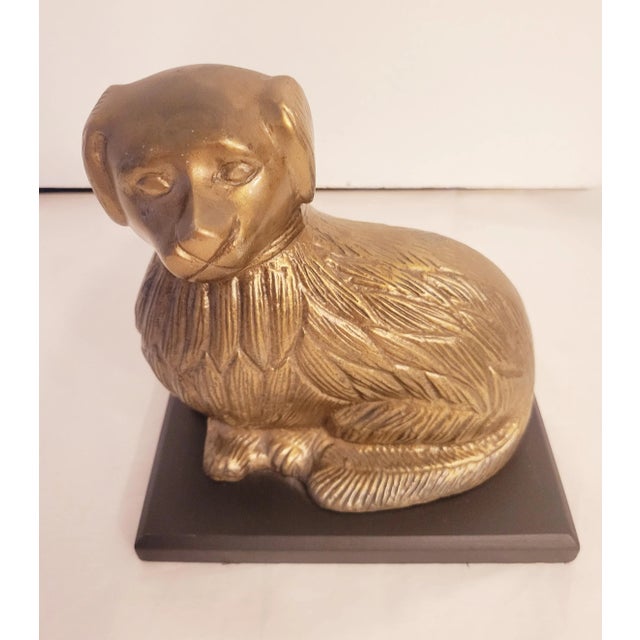 Vintage brass staffordshire dog decorative room decor. The brass staffy sits on a piece of very dark brown, almost black...