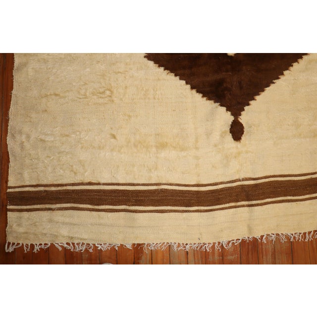Handmade Turkish mohair rug with a chocolate brown off-center medallion on an cream colored ground. Measures: 5'2'' x 6'3''.