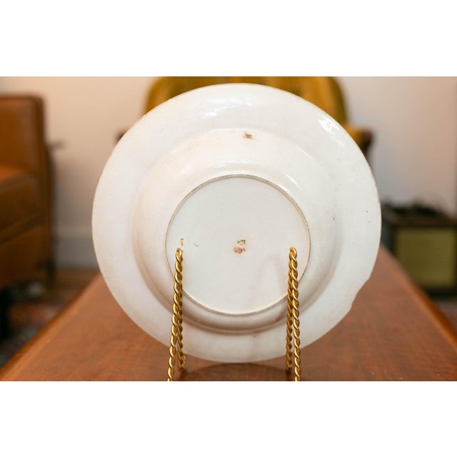 A striking pair of antique English porcelain plates in the richly decorative Imari palette, produced by Royal Crown Derby...