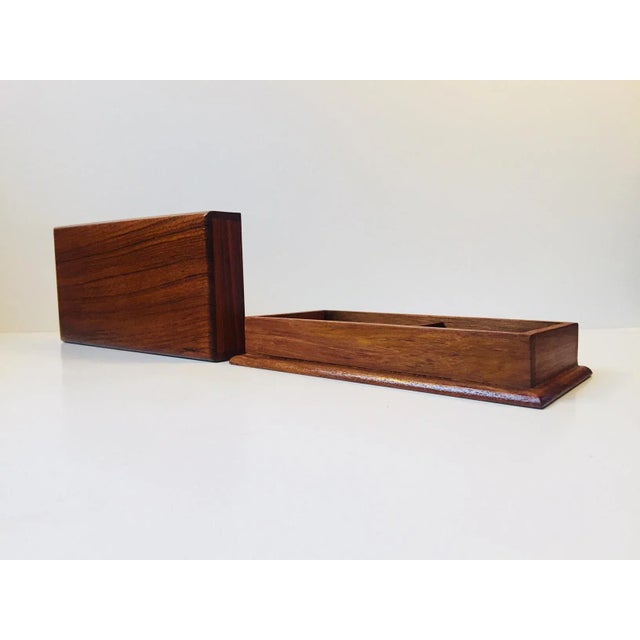 A solid teak box with two compartments suitable for playing cards, cigarettes or jewelry. Made anonymously in Denmark the...