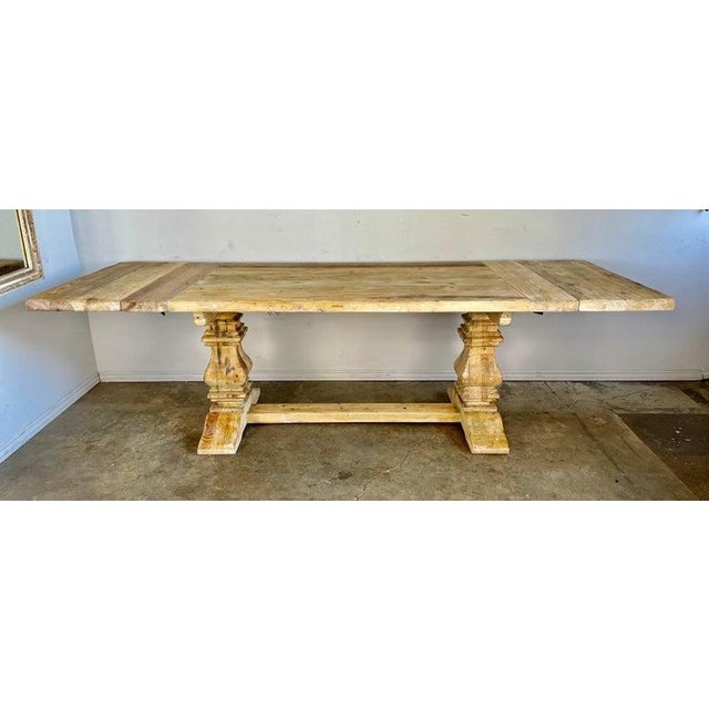 Italian Country pine table with two removable leaves. The table top stands on two pedestals and a bottom stretcher that...