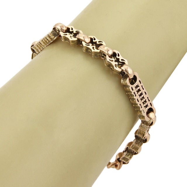 This antique 9k rose gold engraved link bracelet is a timeless piece of fine jewelry that exudes elegance and...