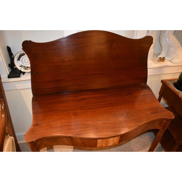 Federal New England mahogany games table circa 1790 to 1810. The serpentine top opens to reveal the playing surface below...