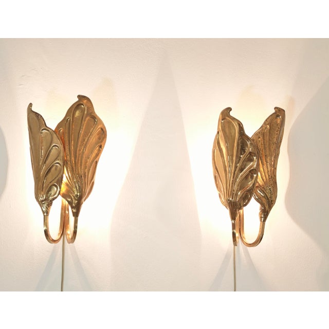 A pair of leaf-shaped brass wall lamps by italian designer tommaso barbi, produced by g&g studio e design, dating back to...