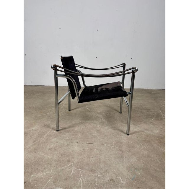 Lc1 armchair by le corbusier, jeanneret, and perriand, manufactured by cassina. Chrome-plated tubular steel frame with a...