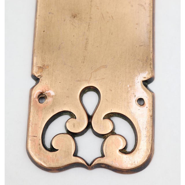 Traditional style brass door push plate with a polished finish and cutout swirl patterns on each end. Made by Reading. The...