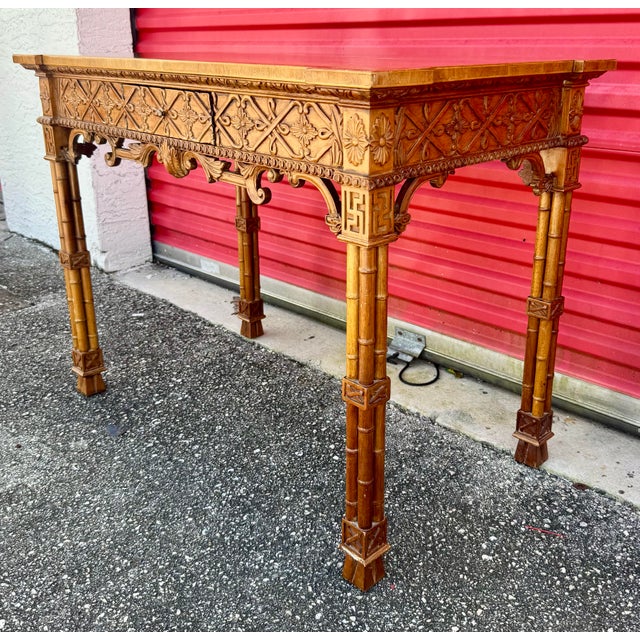 A striking and sophisticated pair of antique Chinese Chippendale console tables, beautifully crafted with intricate faux...