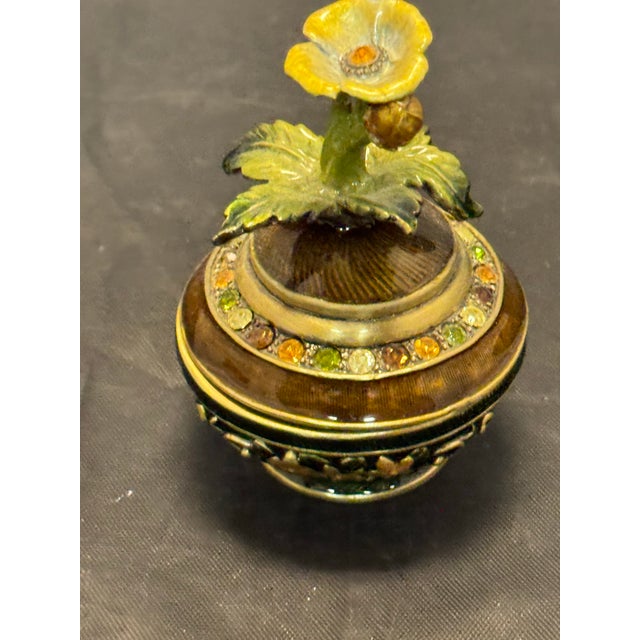 This Vintage Mid Century Enameled Brass Pedestal Trinket Dish features a beautiful floral pattern and a jeweled design,...