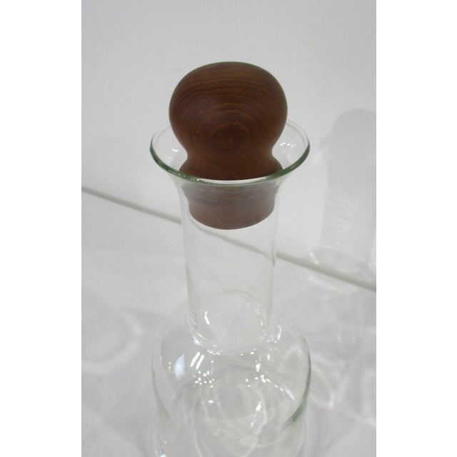 Handblown clear glass wine carafe with rounded teak wood stopper manufactured by Dansk whose iconic service ware and...