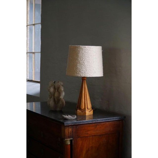 A sculptural danish table lamp crafted in solid beech wood, produced in denmark during the 1970s. The lamp features an...