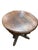 Heavily carved round oak side table characterized by figural supports like winged cherubs and feet shaped like grotesque...
