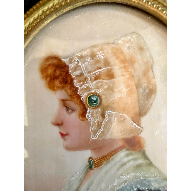 A stunning late 19th-century miniature portrait of a young woman in profile, elegantly housed in an ornate Louis XVI style...