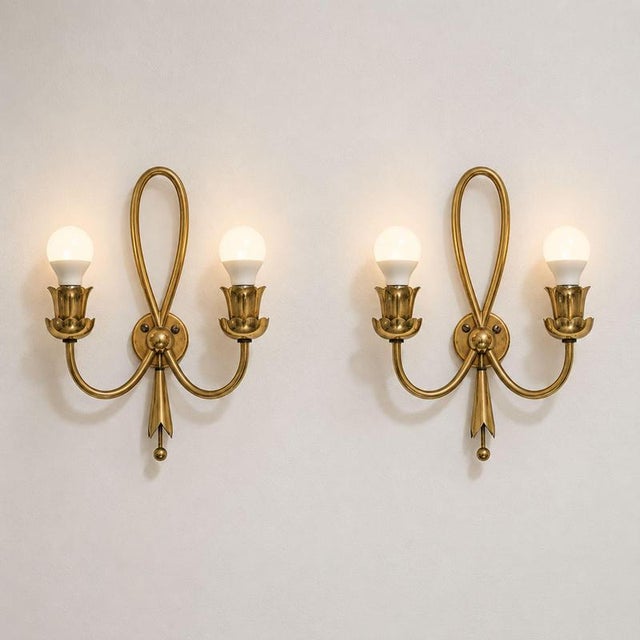 a refined pair of italian mid-century modern brass wall sconces, dating to the late 1940s and attributable to angelo lelii...