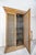 This distinctive cabinet features a warm gold leaf–style finish over a carved wood frame, paired with intricately...